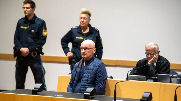 Der wegen der Ermordung von drei Nachbarn angeklagte Mann wird im Gerichtssaal von Polizisten bewacht. Der Mann will nach Angaben seines Anwalts auf Bildern nicht unkenntlich gemacht werden. (Archivfoto) - &copy; Stefan Puchner/dpa