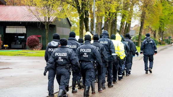 Polizisten gehen auf der Suche nach einem vermissten Jungen durch eine Ortschaft in Niedersachsen. - &copy; Daniel Bockwoldt/dpa