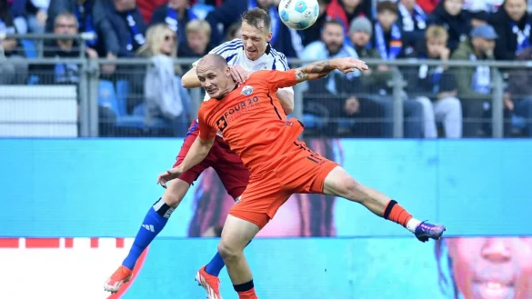Paderborns Sven Michel (vorn) und Hamburgs Sebastian Schonlau k&auml;mpfen um den Ball. - &copy; Daniel Bockwoldt/dpa