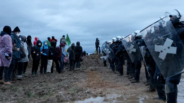 Polizisten stehen Demonstranten am Rande des Braunkohletagebaus bei Lützerath gegenüber (Archivfoto) - © Oliver Berg/dpa