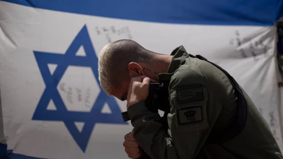 Ein israelischer Soldat neben der Nationalflagge: Gibt es f&uuml;r Israel einen Ausweg aus dem Schlamassel? - &copy; Leo Correa/AP/dpa