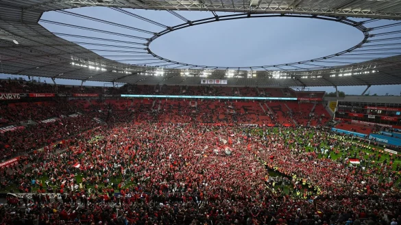 Leverkusens Fans bejubeln auf dem Rasen der BayArena den Gewinn der Deutschen Meisterschaft. - &copy; David Inderlied/dpa