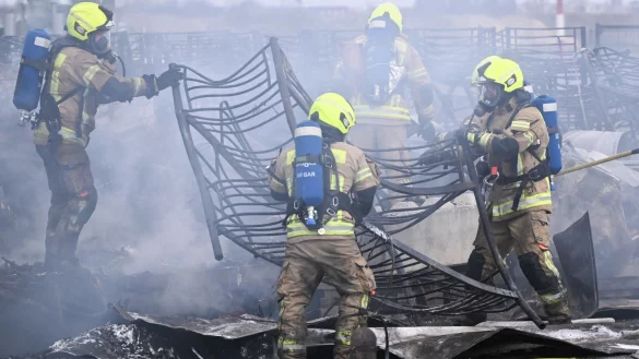 Feuerwehrm&auml;nner l&ouml;schen die letzten Brandstellen in der Fl&uuml;chtlingsunterkunft am ehemaligen Flughafen Tegel. - &copy; Sebastian Gollnow/dpa
