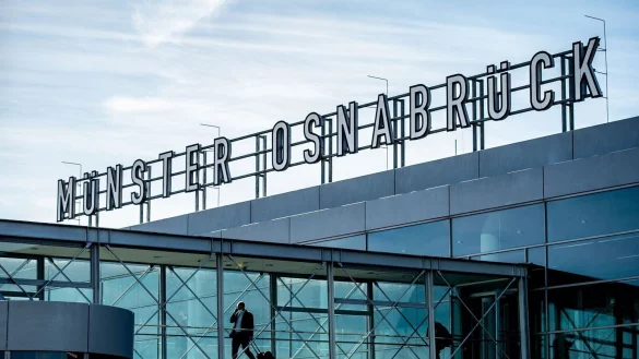 Zwei Passagiere gehen &uuml;ber die Gangway am Flughafen M&uuml;nster-Osnabr&uuml;ck zu ihrem Flieger. - &copy; Guido Kirchner/dpa/Archivbild