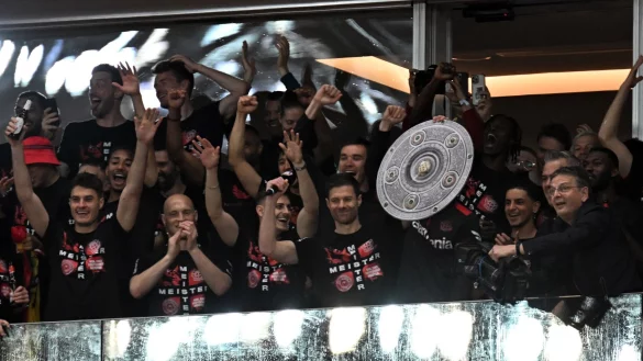 Trainer Xabi Alonso h&auml;lt eine nachgemachte Meisterschale in die H&ouml;he. - &copy; Federico Gambarini/dpa