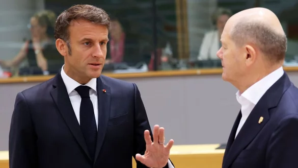 Emmanuel Macron (l), Pr&auml;sident von Frankreich, spricht mit Bundeskanzler Olaf Scholz. - &copy; Geert Vanden Wijngaert/AP/dpa