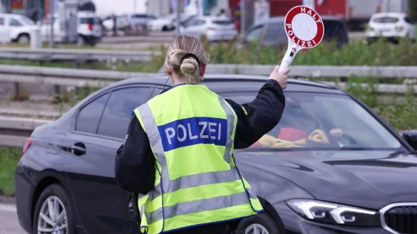 Eine Polizistin winkt bei einer Kontrolle ein Fahrzeug in die Kontrollstelle. - &copy; David Young/dpa