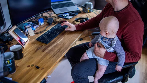 Ein junger Vater im Home-Office mit seinem sechs Monate alten Sohn. - &copy; Jens B&uuml;ttner/dpa