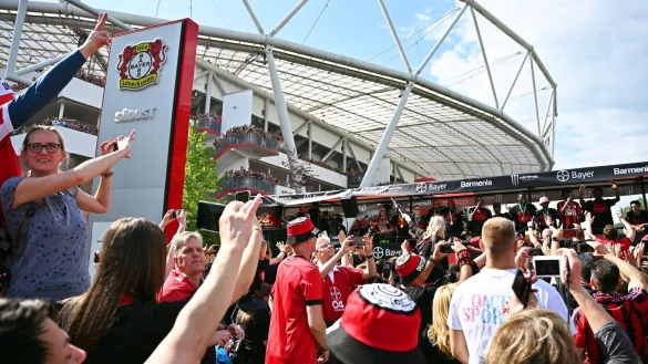 Leverkusens Spieler kommen bei einem Autokorso in einem offenen Bus an der BayArena an. - &copy; David Inderlied/dpa