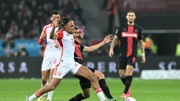 M&uuml;nchens Sacha Boey (l) und Leverkusens Josip Stanisic k&auml;mpfen um den Ball. - &copy; Federico Gambarini/dpa