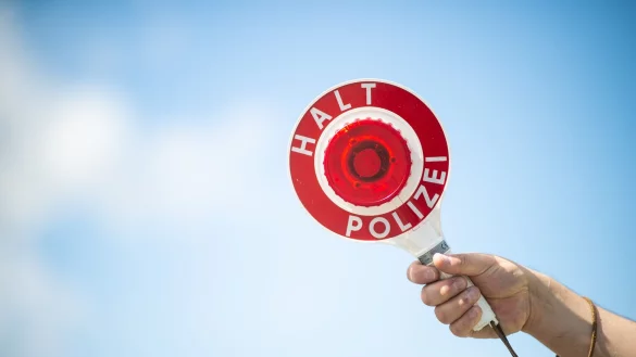 Ein Polizist h&auml;lt eine Polizeikelle. - &copy; Jonas G&uuml;ttler/dpa/Symbolbild