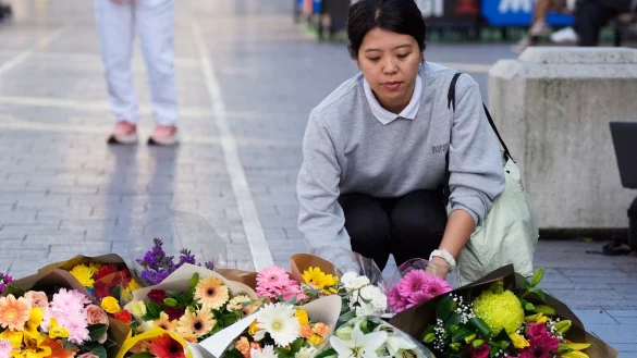 Eine Frau bringt Blumen zu einer improvisierten Gedenkst&auml;tte an der Bondi Junction. - &copy; Rick Rycroft/AP/dpa