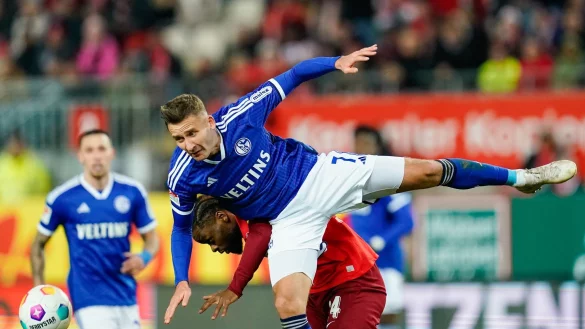 Kaiserslauterns Ba-Muaka Simakala (hinten) und Schalkes Paul Seguin k&auml;mpfen um den Ball. - &copy; Uwe Anspach/dpa