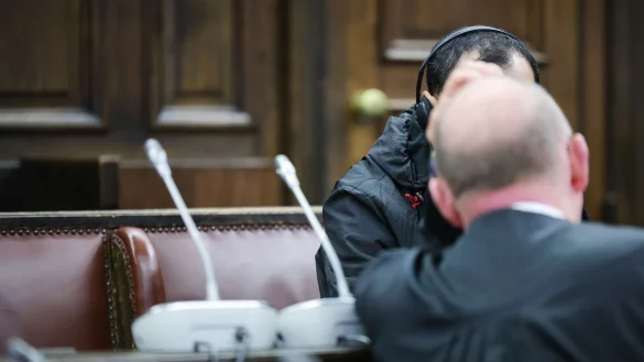 Einer der beiden Angeklagten (verdeckt) spricht mit seinem Anwalt Hannes Linke vor Prozessbeginn im Gerichtssaal des Strafjustizgeb&auml;udes. - &copy; Christian Charisius/dpa-Pool/dpa