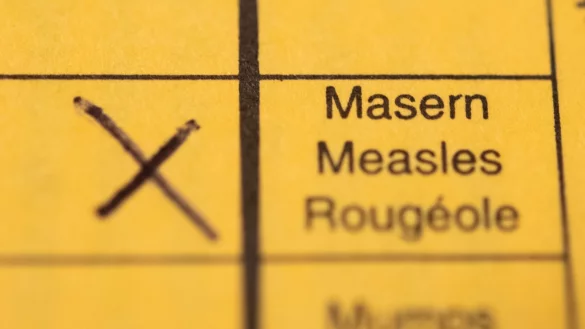 Ein Impfpass mit einem Kreuz bei der Masern-Impfung liegt auf einem Tisch. - &copy; Tom Weller/dpa