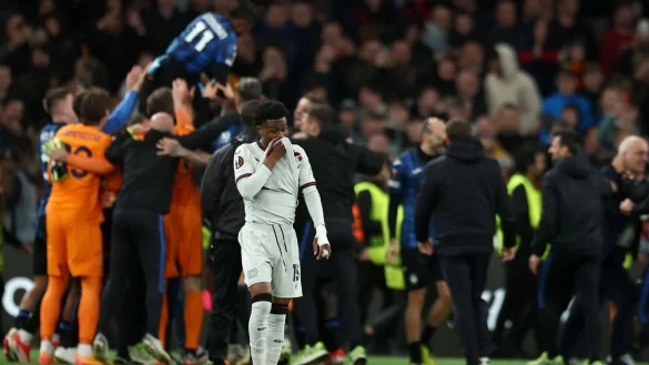 Leverkusens Nathan Tella geht entt&auml;uscht &uuml;ber den Platz, w&auml;hrend im Hintergrund Bergamos Spieler jubeln. - &copy; Jan Woitas/dpa