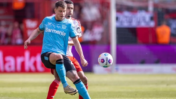 Adam Hlozek von Bayer Leverkusen kämpft gegen Berlins Danilho Doekhi (r) um den Ball. - © Andreas Gora/dpa