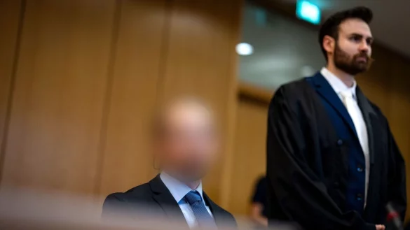 Der Angeklagte sitzt vor dem Prozessbeginn im Gerichtssaal neben seinem Anwalt Nikolai Doszna (r). &Uuml;ber sieben Jahre nach Verschwinden einer Frau im Kreis Heinsberg kommt der Ehemann wegen Mordes vor Gericht. - &copy; Christoph Reichwein/dpa