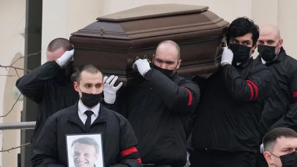M&auml;nner tragen den Sarg und ein Portr&auml;t des russischen Oppositionsf&uuml;hrers Alexej Nawalny aus der Kirche. - &copy; AP/dpa