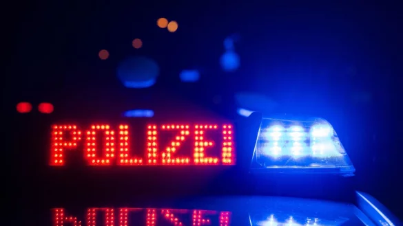 Zwei Polizisten stehen im Rahmen eines Fototermins vor einem Polizeifahrzeug. - &copy; Marijan Murat/dpa/Archivbild