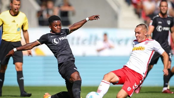 Regensburg-Kapitän Andreas Geipl (r) kämpft gegen den Münsteraner Daniel Kyerewaa um den Ball. - © Daniel Karmann/dpa