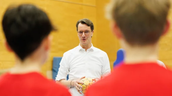 Hendrik W&uuml;st (CDU), Ministerpr&auml;sident von Nordrhein-Westfalen, spricht mit Handball-Spielern. - &copy; Friso Gentsch/dpa