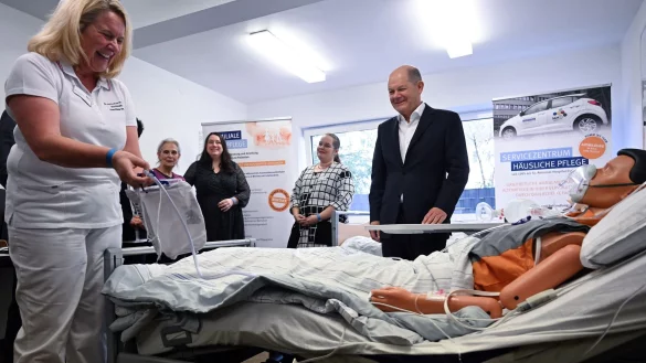 Bundeskanzler Olaf Scholz (SPD) spricht beim Besuch des St. Antonius Hospitals in Eschweiler mit Monika Conzen (l), Pflegeberaterin über die familiale Pflege. - © Federico Gambarini/dpa