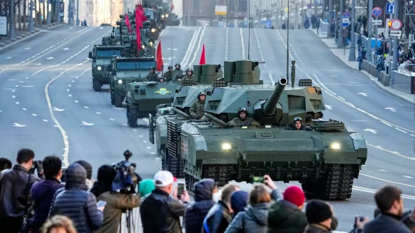 Zuschauer beobachten im Mai 2022, wie ein russischer T-14 Armata-Panzer (im Vordergrund) und andere gepanzerte Fahrzeuge auf der Twerskaja-Stra&szlig;e in Richtung Roter Platz rollen. - &copy; Alexander Zemlianichenko/AP/dpa