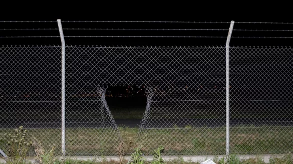 Durch ein Loch im Zaun verschafften sich die Aktivisten Zugang zum Flughafengel&auml;nde. - &copy; Julius-Christian Schreiner/dpa