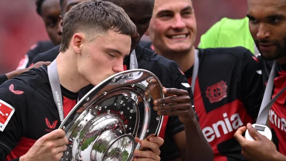 Leverkusens Florian Wirtz k&uuml;sst die Meisterschale. - &copy; Marius Becker/dpa