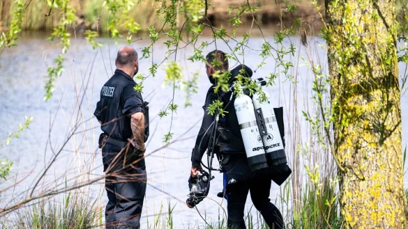 Ein Taucher der Polizei steigt in die Oste. - &copy; Sina Schuldt/dpa