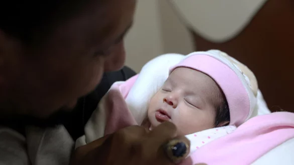 Adoptivvater Chalil Sawadi betrachtet Afraa wenige Tage nach ihrer Geburt. Das kleine M&auml;dchen wurde unter Tr&uuml;mmern des Erdbebens in Syrien am 6. Februar 2023 geboren. - &copy; Ghaith Alsayed/AP/dpa