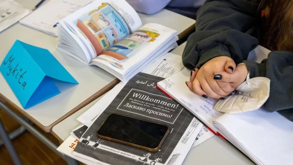 Ein M&auml;dchen aus der Ukraine sitzt mit ihrem Unterrichtsmaterial in einer Klasse. - &copy; Peter Kneffel/dpa