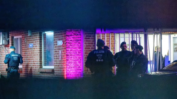 Polizisten und Zollbeamte stehen w&auml;hrend einer Razzia in einem Saunaclub vor dem Geb&auml;ude. - &copy; Henning Kaiser/dpa