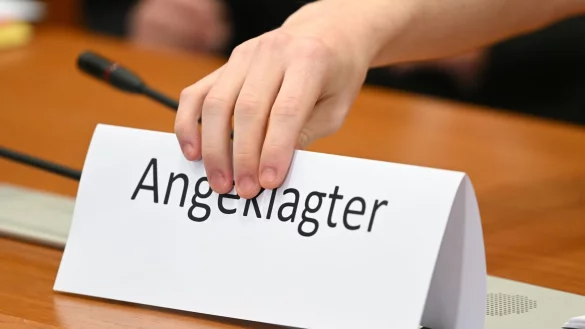 Ein Schild mit der Aufschrift "Angeklagter" wird auf die Gerichtsbank gestellt. - &copy; Arne Dedert/dpa/Symbolbild