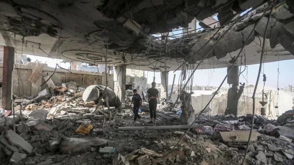 Pal&auml;stinenser stehen in den Tr&uuml;mmern eines Hauses nach einem israelischen Luftangriff, bei dem mehrere Menschen get&ouml;tet wurden. - &copy; Ismael Abu Dayyah/AP/dpa