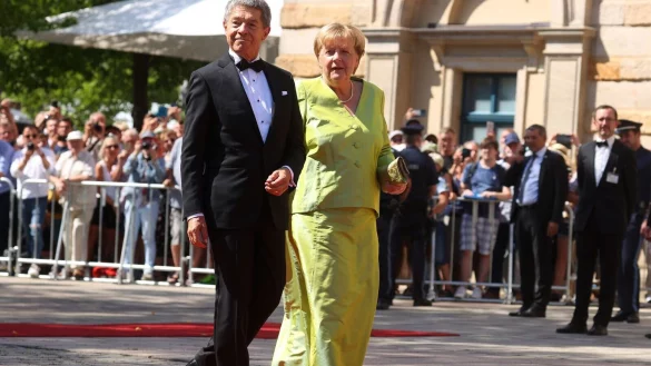 Angela Merkel mit Ehemann Joachim Sauer bei der Er&ouml;ffnung der Bayreuther Richard-Wagner-Festspiele 2022: Wegen ihres leuchtend gr&uuml;nen Outfits wurde auch die ehemalige Bundeskanzlerin in den sozialen Medien zum &laquo;Brat Girl&raquo; ernannt. - &copy; Karl-Josef Hildenbrand/dpa/dpa-tmn
