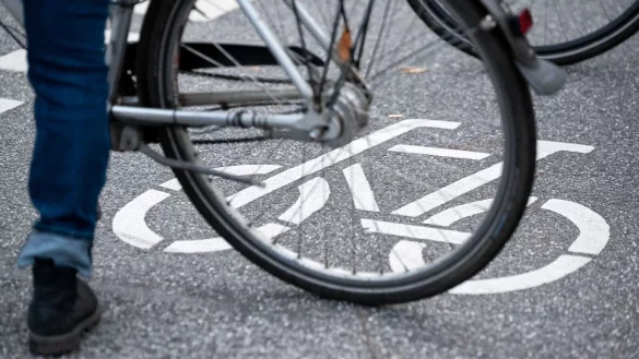 Ein Fahrrad-Symbol ist auf der Fahrbahn einer Stra&szlig;e hinter einem Fahrrad zu sehen. - &copy; Jonas Walzberg/dpa