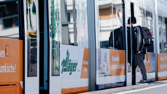 Ein junger Mann steigt an einer Stra&szlig;enbahnhaltestelle in eine Stra&szlig;enbahn ein. - &copy; Uwe Anspach/dpa