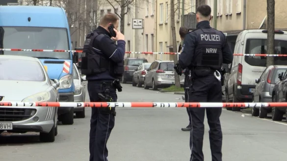 Zwei Beamte stehen an einem abgesperrten Tatort. - &copy; Justin Brosch/dpa