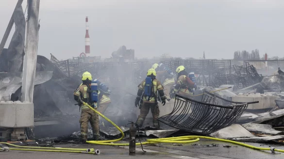 Die Feuerwehr l&ouml;scht die Brandstelle bei der Fl&uuml;chtlingsunterkunft am ehemaligen Flughafen Tegel. Die Nachl&ouml;scharbeiten sind inzwischen abgeschlossen. - &copy; Carsten Koall/dpa