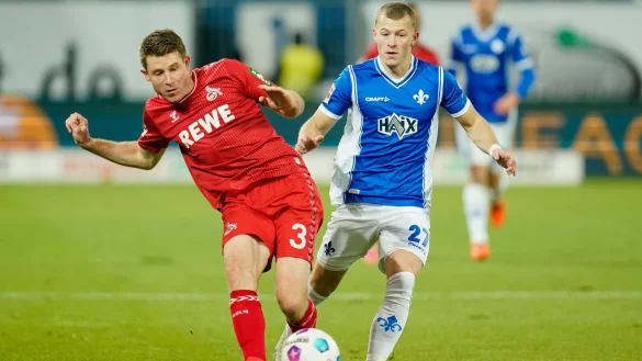 K&ouml;lns Dominique Heintz (l) und Darmstadts Tim Skarke k&auml;mpfen um den Ball. - &copy; Uwe Anspach/dpa