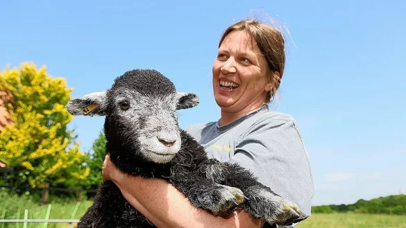 Z&uuml;chterin D&ouml;rte G&uuml;th umarmt eines der im April neugeborenen L&auml;mmer ihrer Schafherde. - &copy; FOTO: REIMAR OTT
