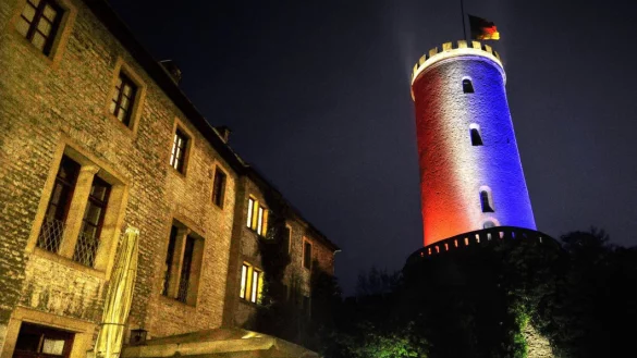 Bielefelder Anteilnahme: Seit Samstagabend leuchtet der Bielefelder Sparrenburgturm als Zeichen der Solidarit&auml;t in den Farben der franz&ouml;sischen "Tricolore". Die Deutschlandflagge oben h&auml;ngt wegen des Volkstrauertages auf Halbmast. - &copy; Andreas Fr&uuml;cht