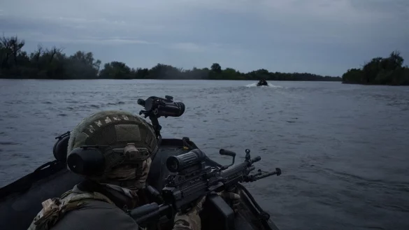 Ukrainische Soldaten fahren mit einem Boot auf dem Fluss Dnipro an der Frontlinie in der Nähe von Cherson. - © Felipe Dana/AP/dpa