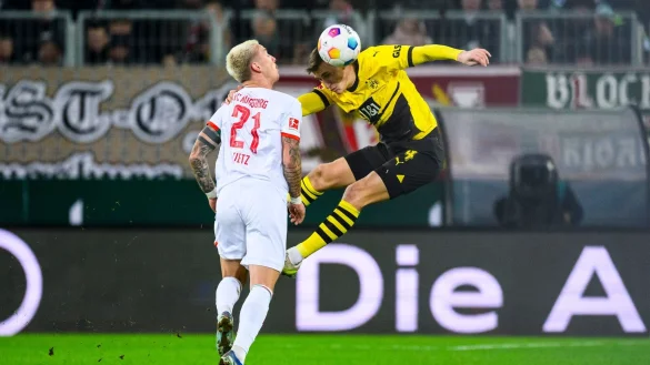 Dortmunds Nico Schlotterbeck (r) in Aktion gegen Augsburgs Phillip Tietz (l). - &copy; Tom Weller/dpa