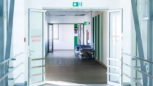 Krankenbetten stehen in einem Gang in einem Krankenhaus. - © Lukas Barth/dpa/Symbolbild