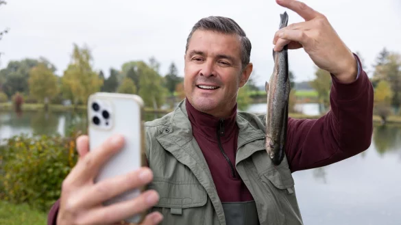 Stolz posiert Wirt Jo (Christian K. Schaeffer) f&uuml;r ein Selfie, das seinen erfolgreichen Fischfang dokumentieren soll. - &copy; Markus Sapper/ZDF/dpa