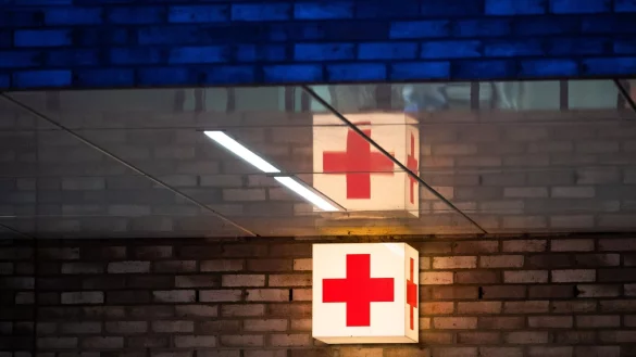 Ein Leuchtkasten mit einem roten Kreuz h&auml;ngt vor der Notaufnahme eines Krankenhauses. - &copy; Julian Stratenschulte/dpa/Symbolbild