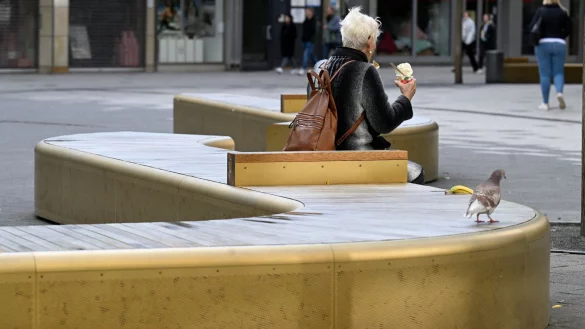 Eine Frau sitzt auf einer der goldenen B&auml;nke in Wuppertal. - &copy; Roberto Pfeil/dpa